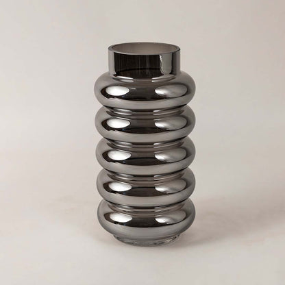 Ripple textured smoky glass vase photographed on white surface showcasing sleek glossy finish and curved modern form.