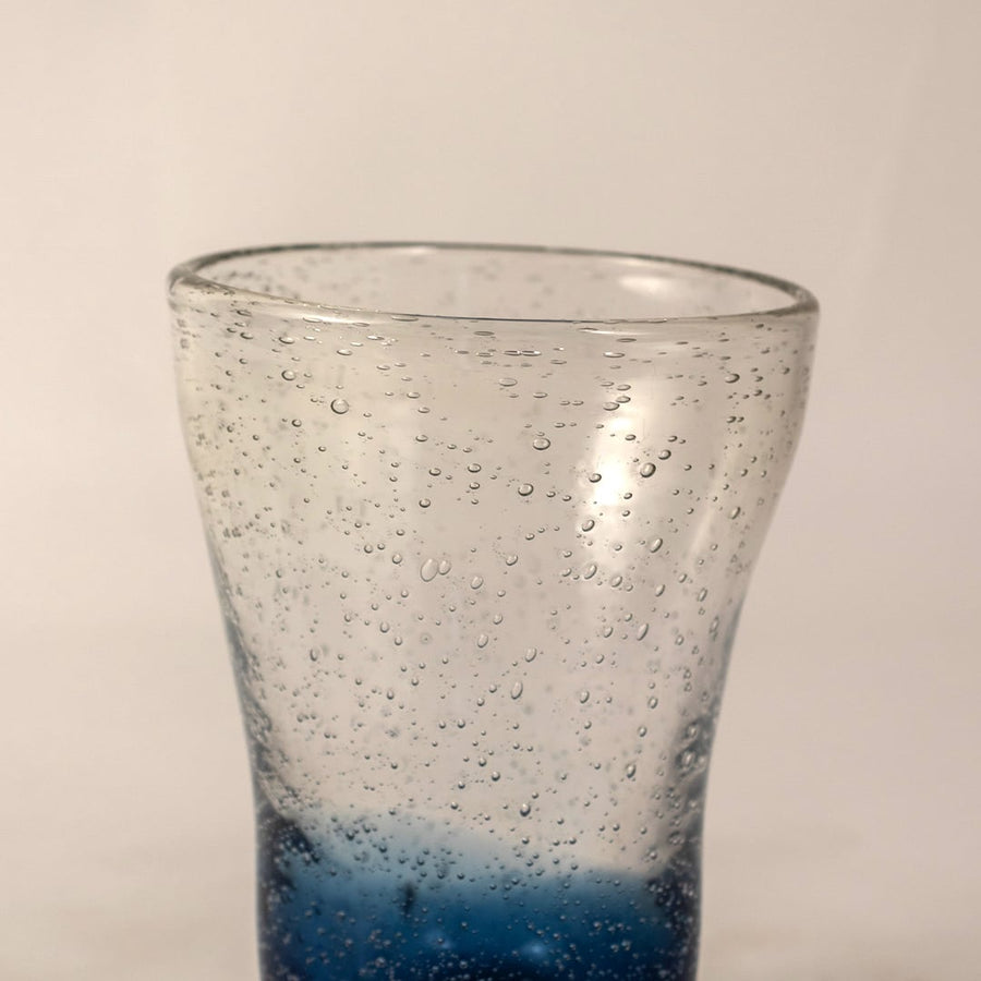 Closeup of blue bubble glass vase showing tiny air bubbles and smooth curved handcrafted finish.