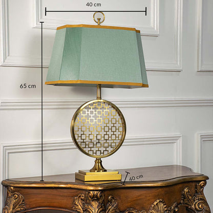 Green shade gold frame round table lamp on carved console table with light off for artistic decorative home décor.