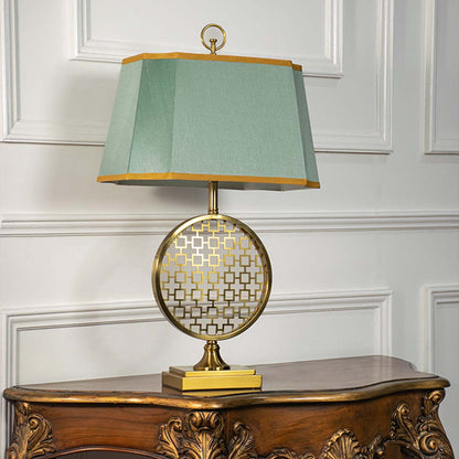 Green shade gold frame table lamp on carved console table with light off for artistic decorative home décor.