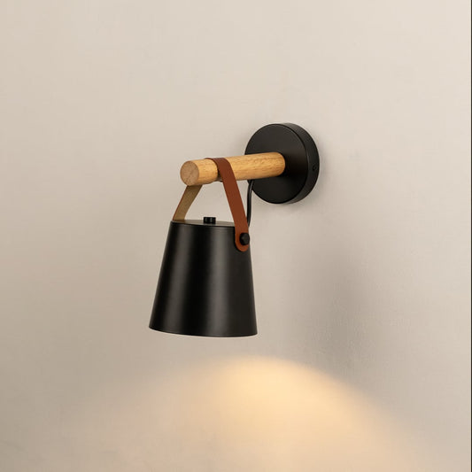Black metal wall light with wooden handle glowing softly on white background ideal for warm modern interiors.