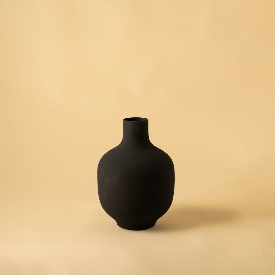 Black modern metal vase displayed on a clean white background highlighting its textured finish and elegant silhouette.