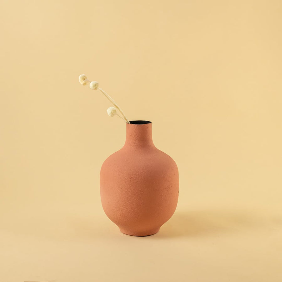 Terracotta textured metal vase styled in a warm neutral scene adding earthy modern charm to contemporary home decor.