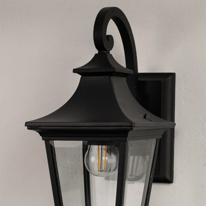Closeup of black metal outdoor wall lantern with clear glass panels showing detailed classic outdoor lighting design.