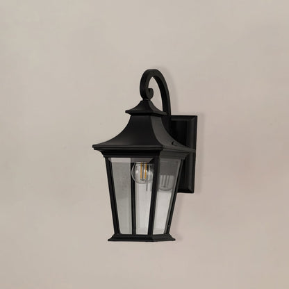 Black metal outdoor wall lantern with clear glass panels shown off on white background for exterior wall use.