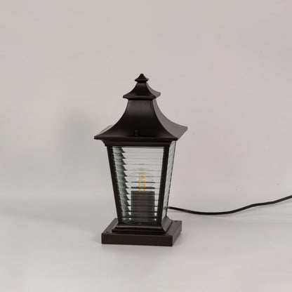 Black metal pillar lamp with ribbed glass panels shown switched off on a white background for outdoor decor.