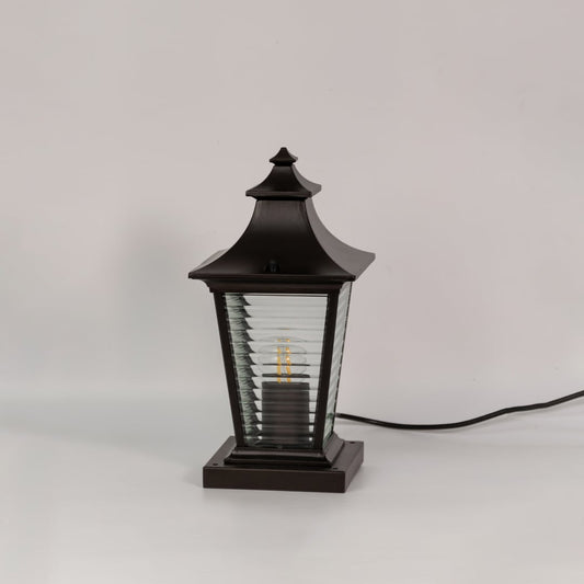 Black metal pillar lamp with ribbed glass panels shown switched off on a white background for outdoor decor.