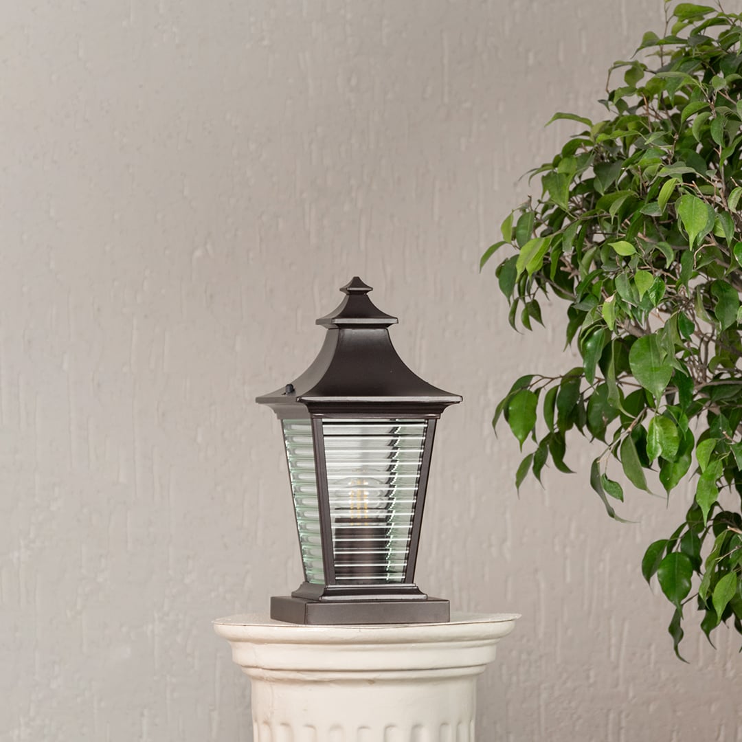 Stylish outdoor black metal pillar light with textured glass body displayed on a white background for porch lighting.