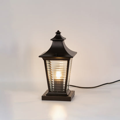 Vintage black outdoor gate light with warm glowing ribbed panels for stylish exterior decor use.