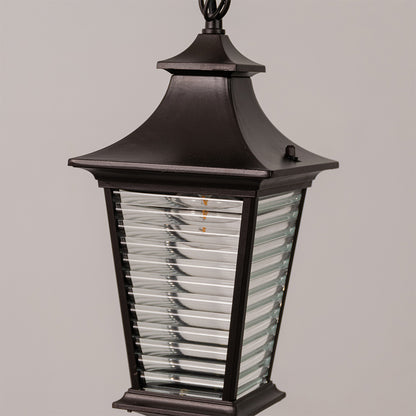 Closeup outdoor wall lantern in black metal with ribbed glass panels for entrance or facade decor lighting white background.