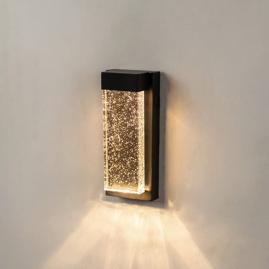 Modern black aluminum outdoor wall sconce on white background with a bubbling crystal glass block for patio decor.