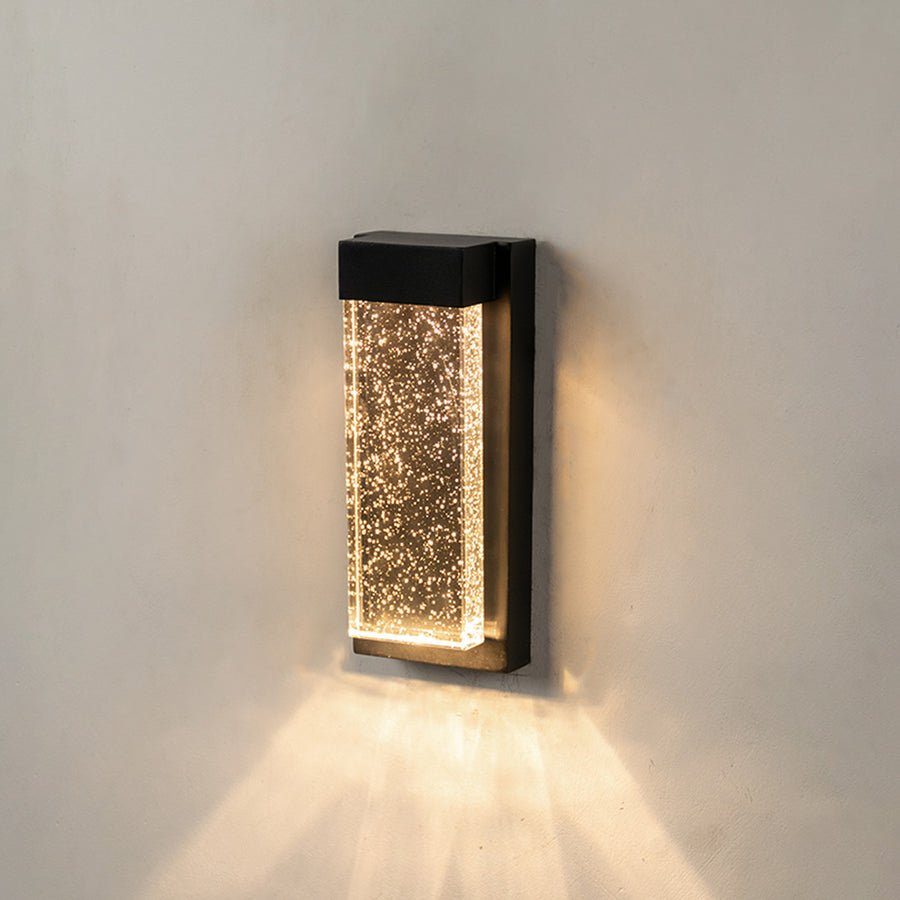 Modern black aluminum outdoor wall sconce on white background with a bubbling crystal glass block for patio decor.