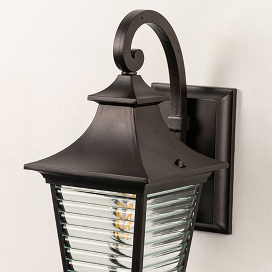 Closeup view of lantern wall light with ribbed glass detailing and matte black frame showing premium craftsmanship.