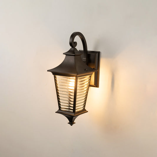 Black metal outdoor wall light on white background with a horizontal ribbed glass lantern for balcony decor.