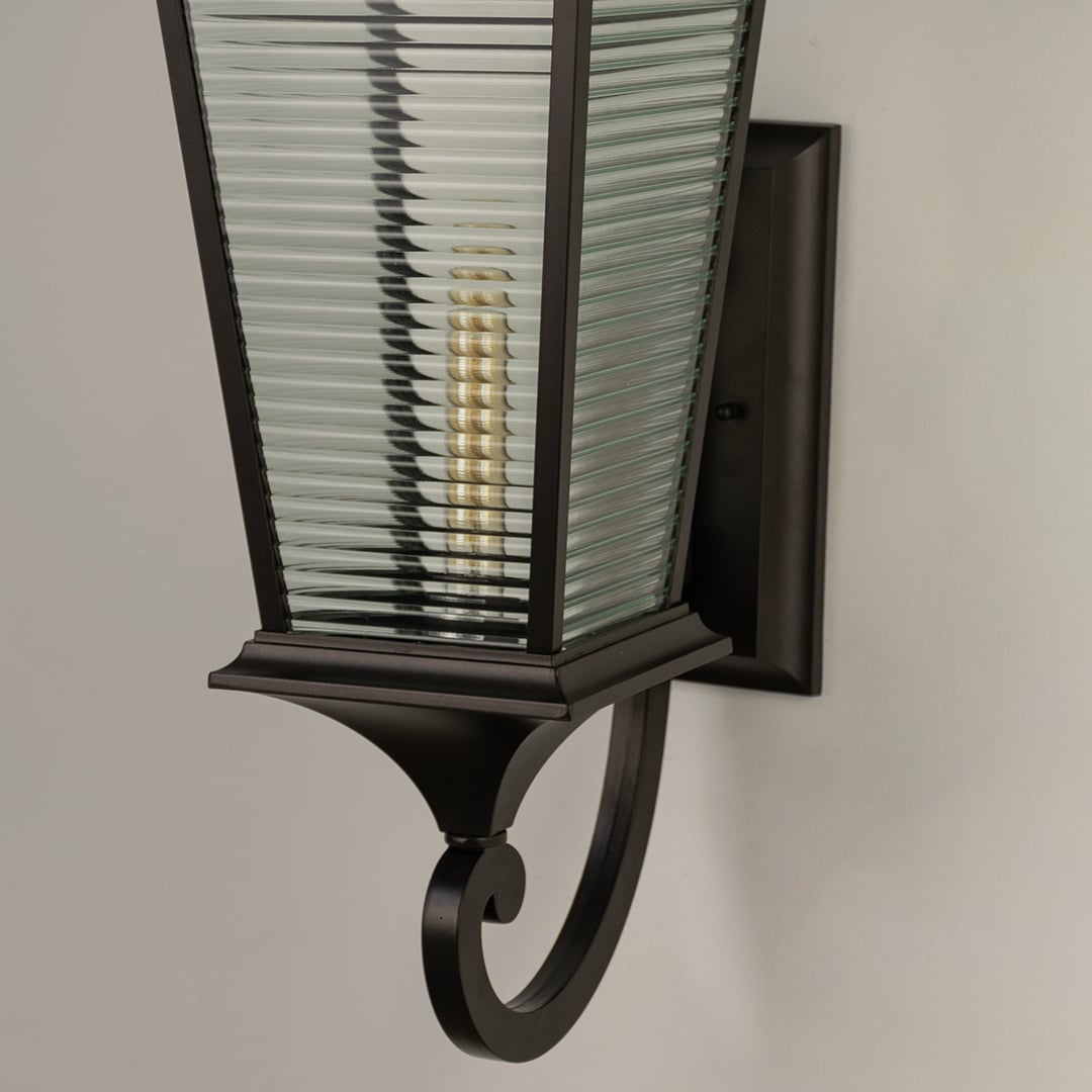 Closeup view of the large black metal outdoor lantern showing the detailed frame and the texture of the ribbed glass panels.