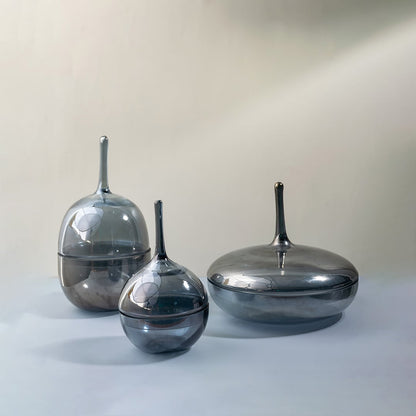 Set of glossy grey glass jars styled together in different sizes creating chic decorative accents for interiors.