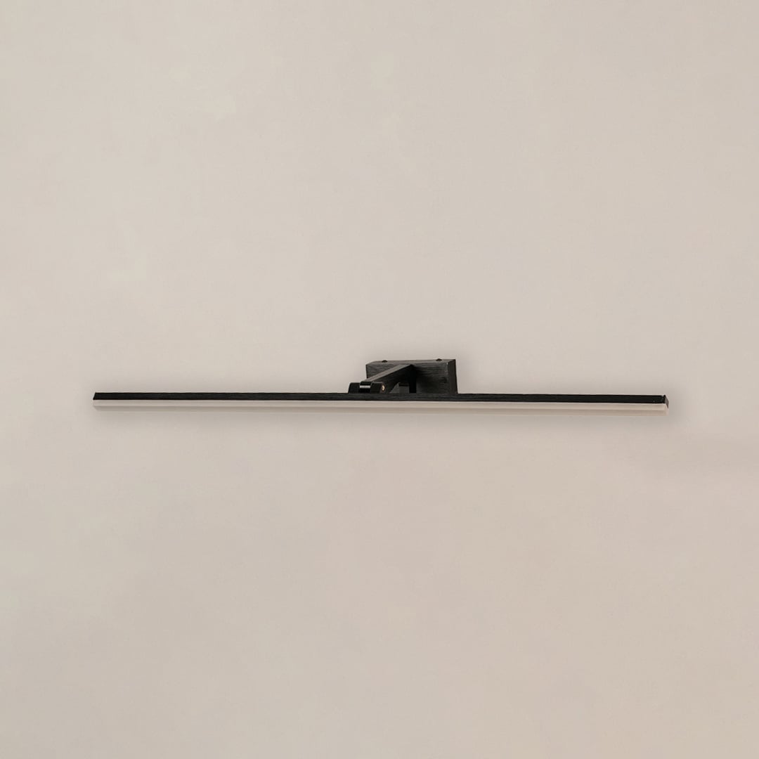 Black metal picture light on a white background with the light off highlighting its minimal modern design.