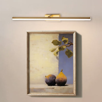 Closeup lifestyle view of gold metal picture light enhancing artwork with warm focused directional illumination.