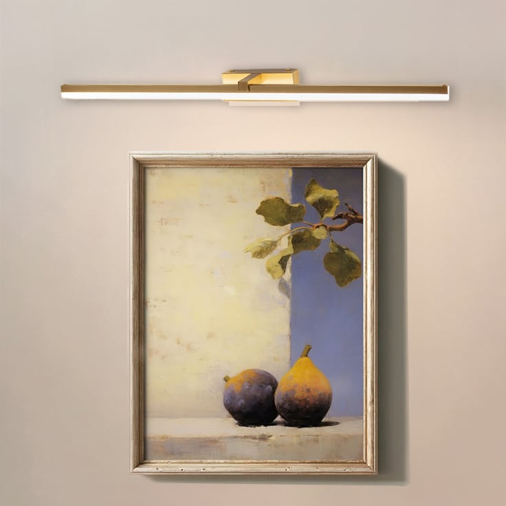 Closeup lifestyle view of gold metal picture light enhancing artwork with warm focused directional illumination.