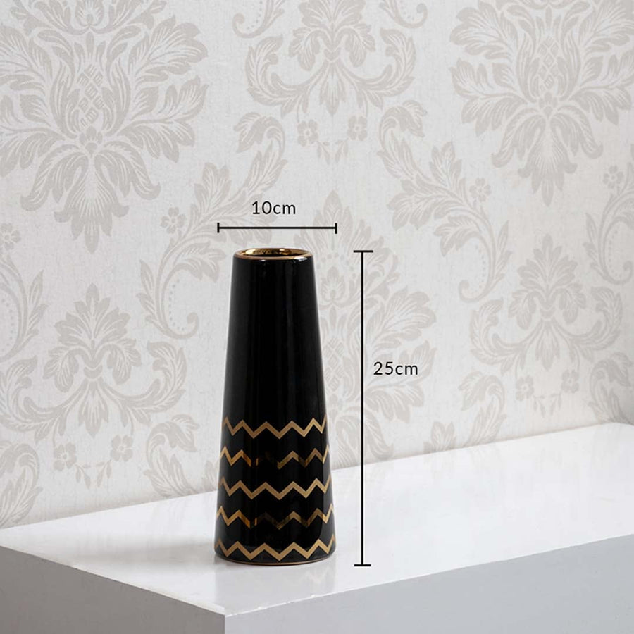 A black ceramic vase with gold zigzag accents shown with measurements of 25 cm height and 10 cm width clearly presenting its decorative size.