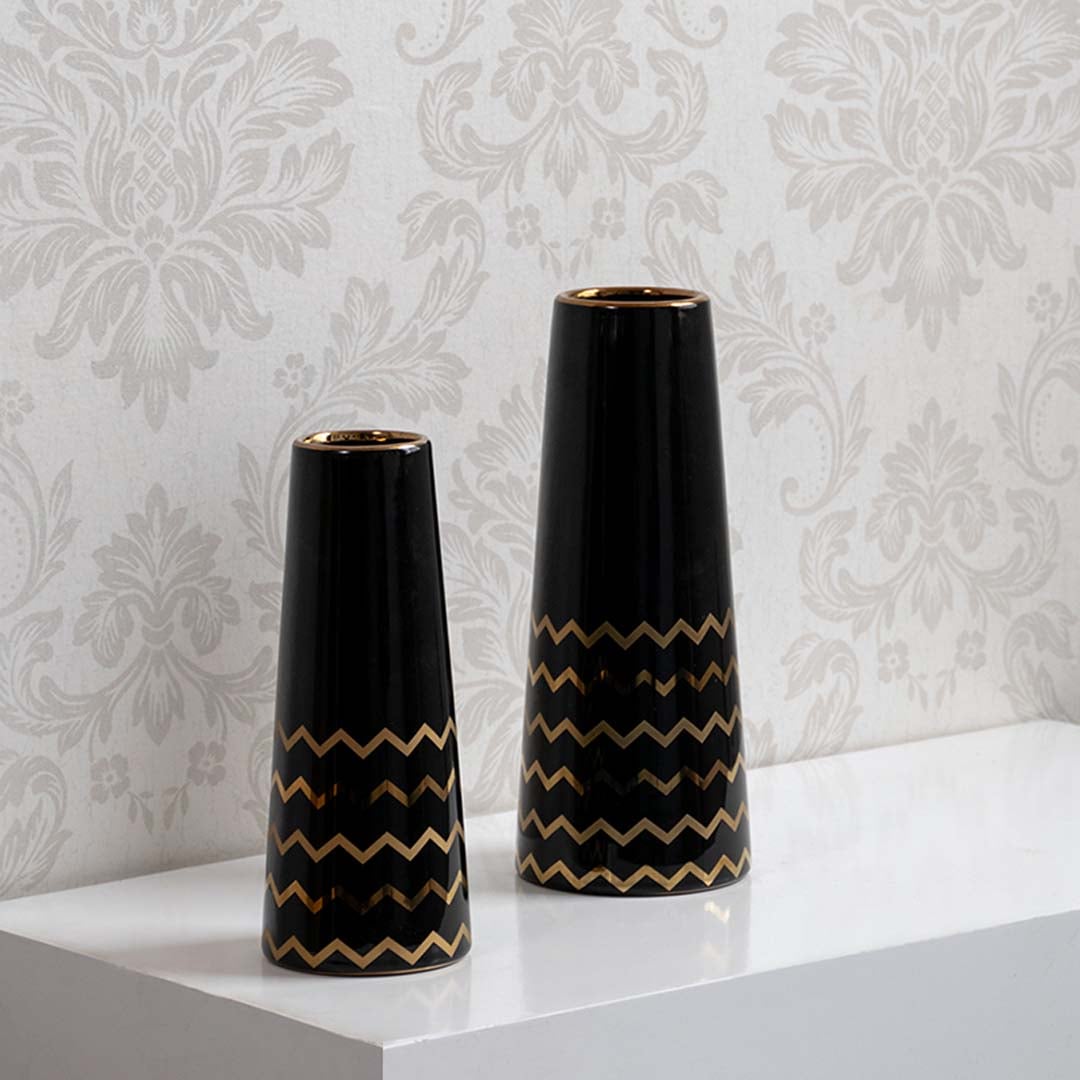 A decorative black vase with gold zigzag design displayed in a curated setup showcasing its modern glossy finish and elegant contemporary look.