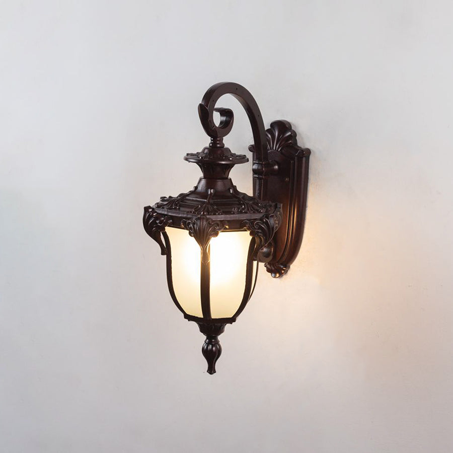 Classic bronze metal outdoor wall light on white background with frosted glass lantern shade for front entryway decor.