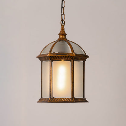 Decorative hanging lantern light turned on against a white background with a warm glow highlighting its antique frame and frosted glass panels.