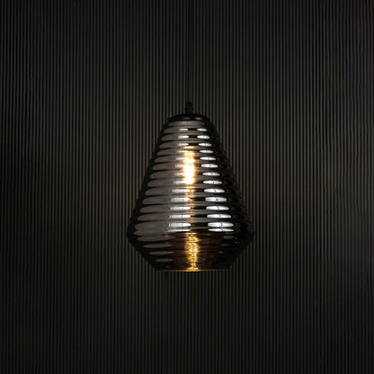 Elegant smoked glass pendant light illuminated on dark background highlighting artistic ribbed texture and refined design appeal.