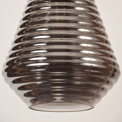 Close view of smoked glass pendant light showing ribbed detailing smooth surface and polished craftsmanship with modern elegance.