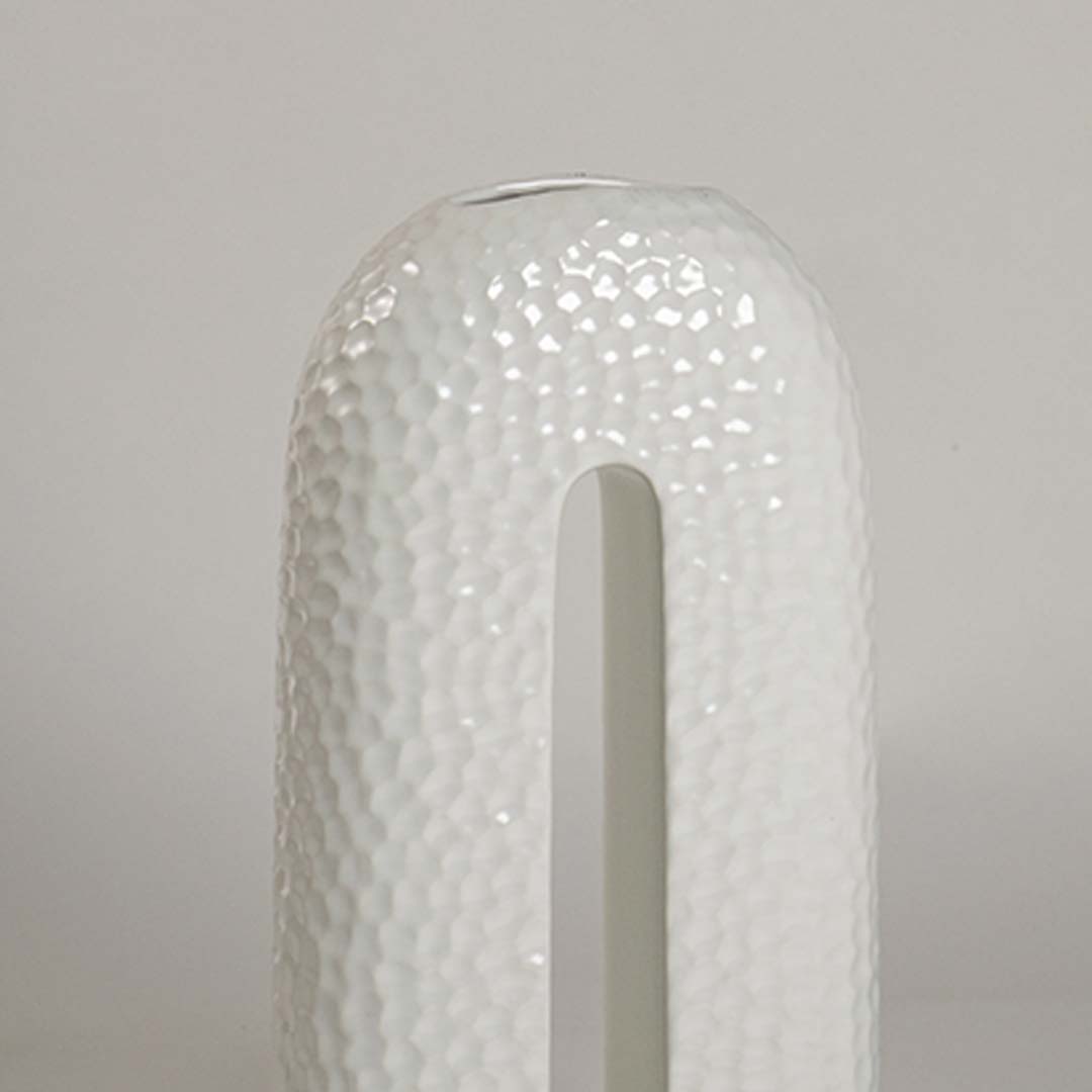 Closeup showing detailed texture and glossy surface of handcrafted white ceramic U-shaped decorative vase.
