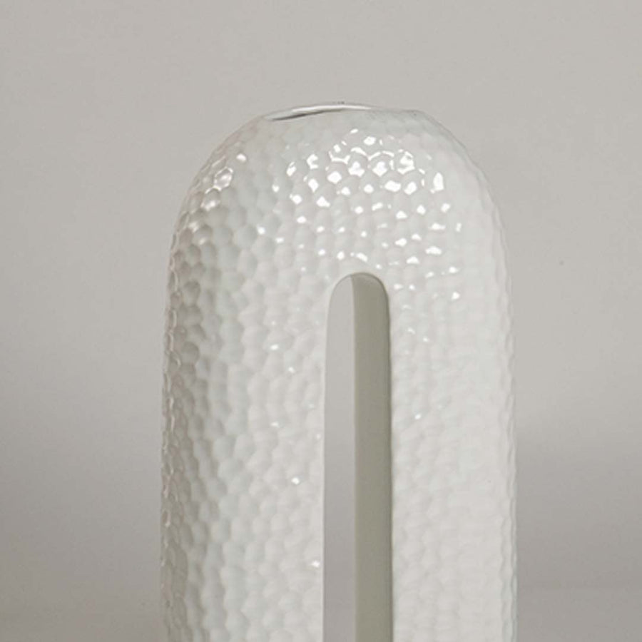 Closeup showing detailed texture and glossy surface of handcrafted white ceramic U-shaped decorative vase.
