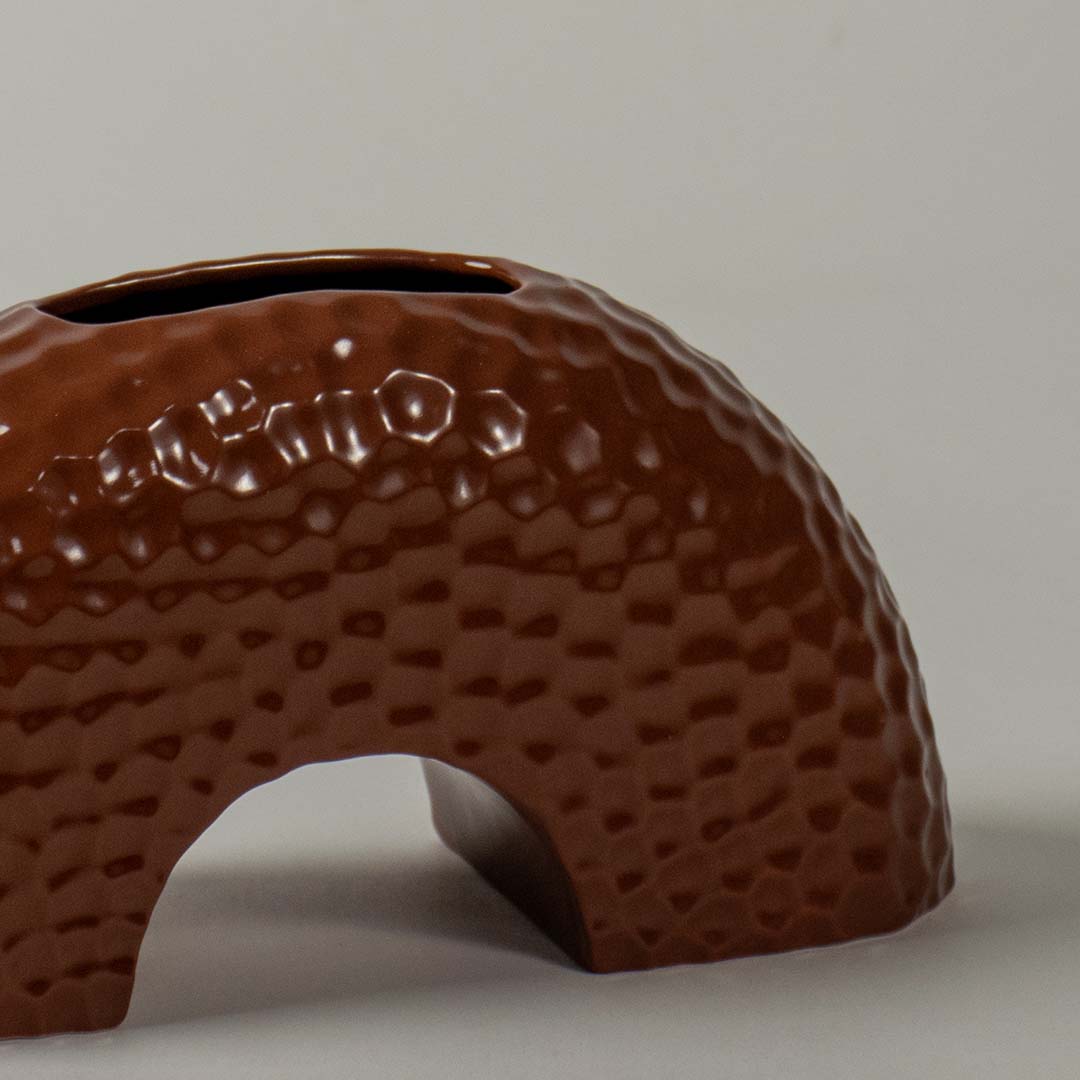 Closeup view of the brown textured arched ceramic vase highlighting its surface details  curved shape  and smooth glossy finish.