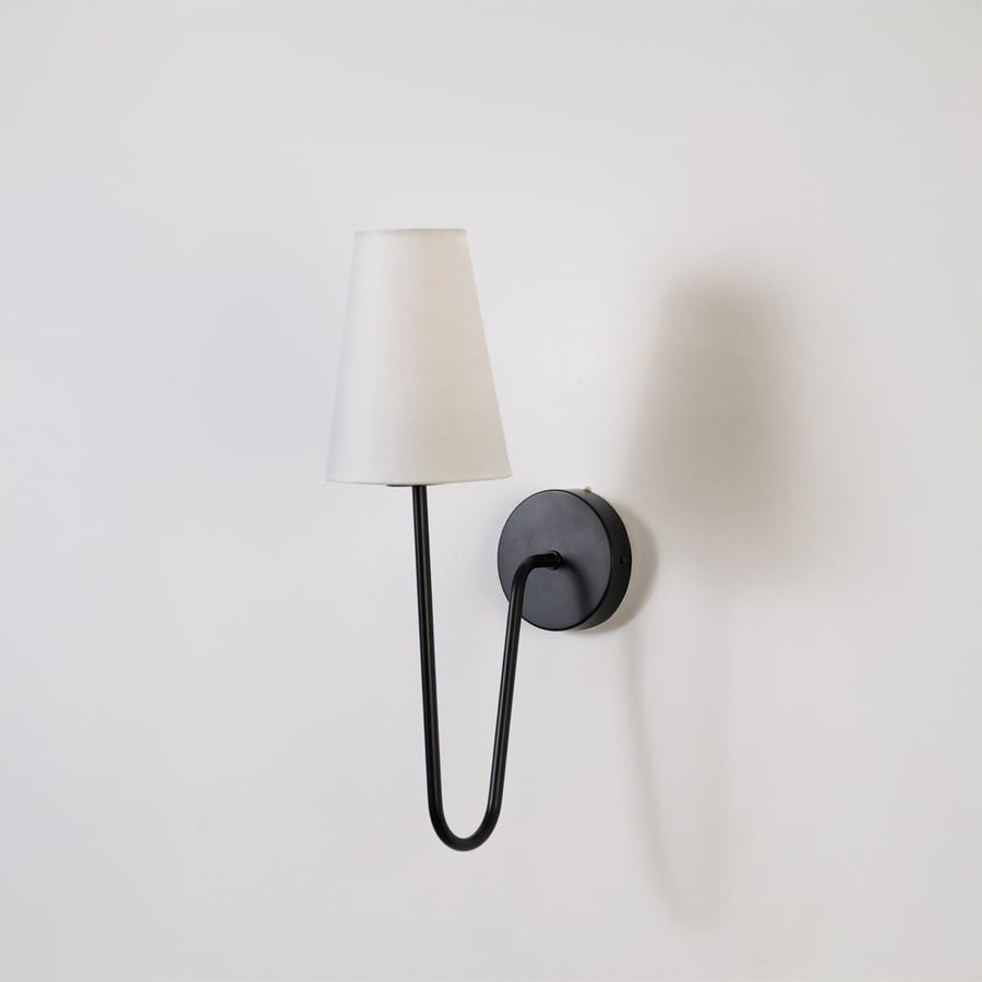 Stylish black wall light with a tall white shade displayed on a plain white background ideal for modern bedroom hallway or living room lighting.