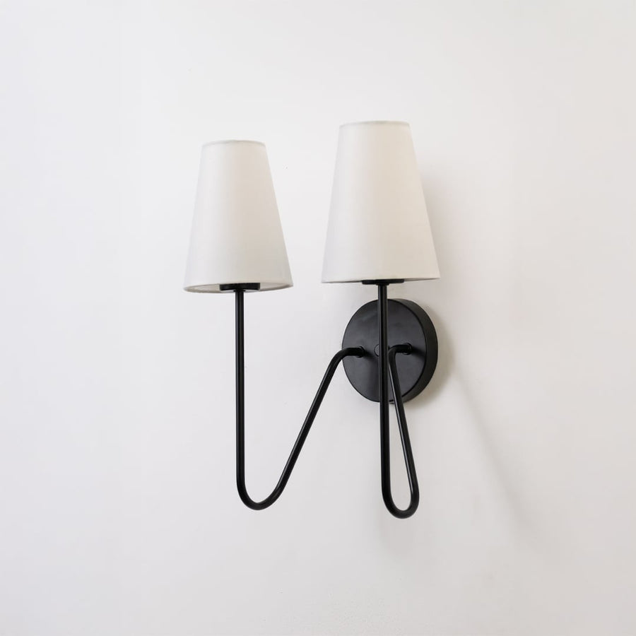 Stylish black double wall light with twin white shades displayed on a white background ideal for bedroom hallway or living room lighting.