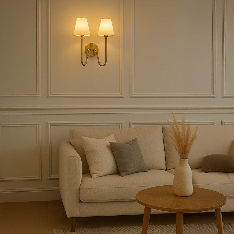 Modern double wall light with gold metal frame and twin white shades adding warm style to bedroom hallway or living space decor.