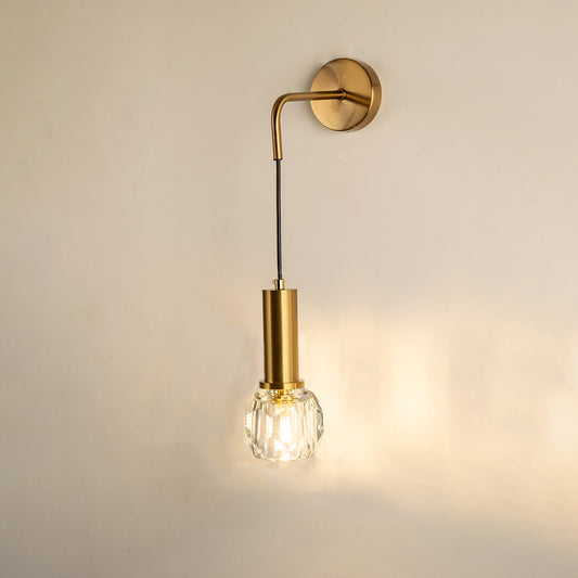 Gold metal wall light with hanging bulb design emitting warm glow ideal for bedroom or hallway wall decor placement.
