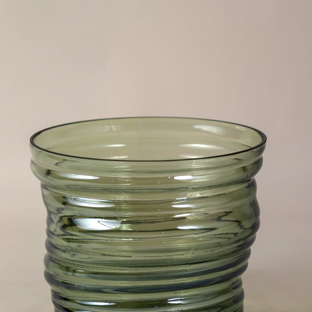 Closeup of green ribbed glass vase showcasing detailed texture  curved design  and high-quality transparent glass finish.
