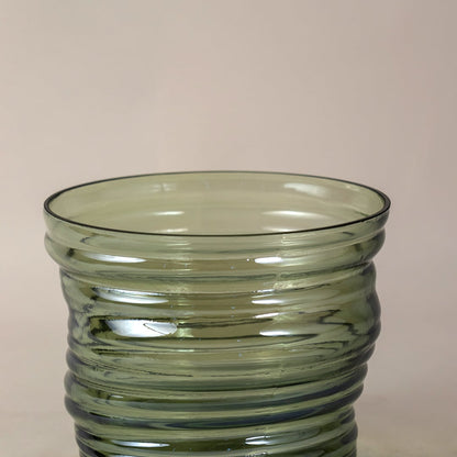 Closeup of green ribbed glass vase showcasing detailed texture  curved design  and high-quality transparent glass finish.