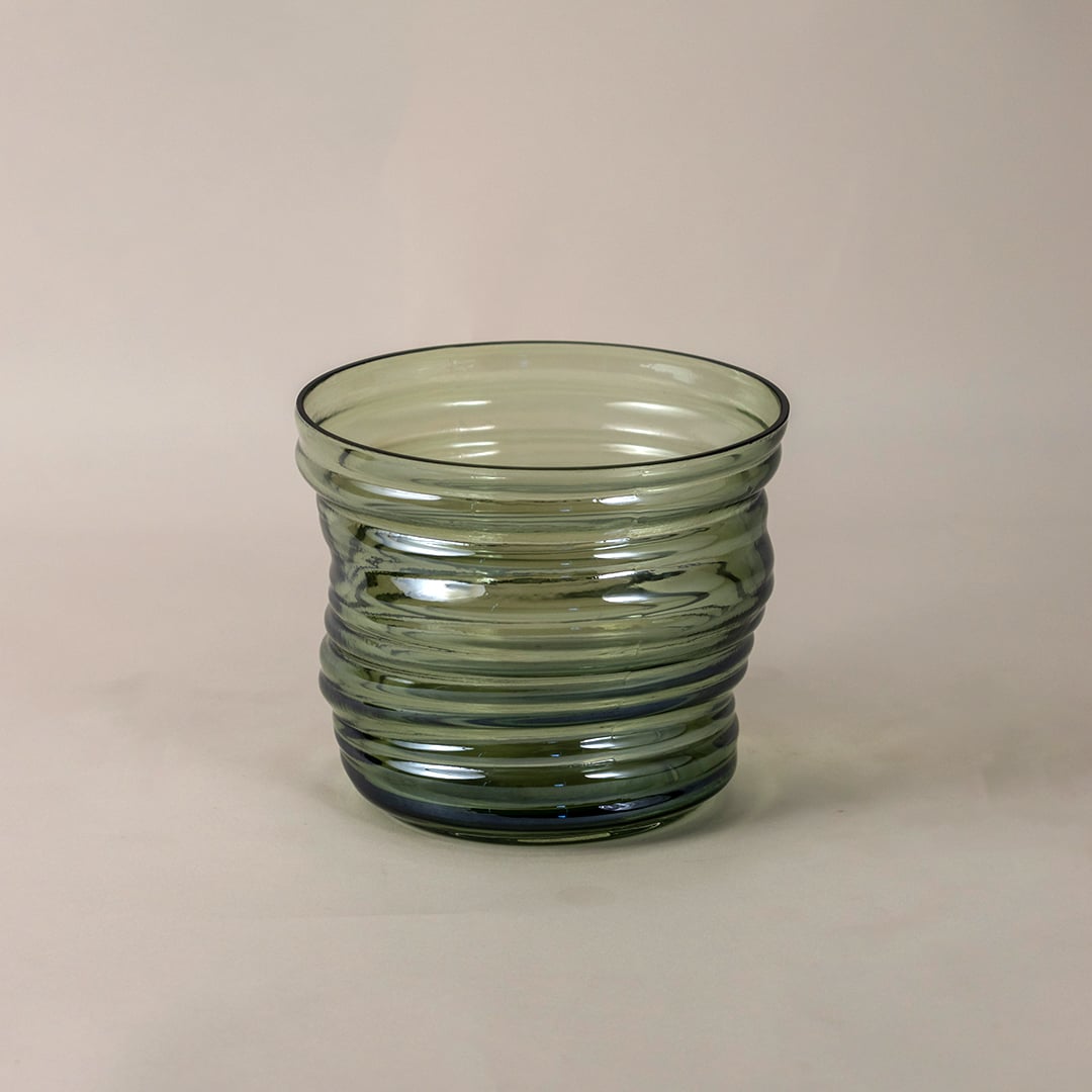 Side view of green ribbed glass vase highlighting its artistic contours and symmetrical ripple design.