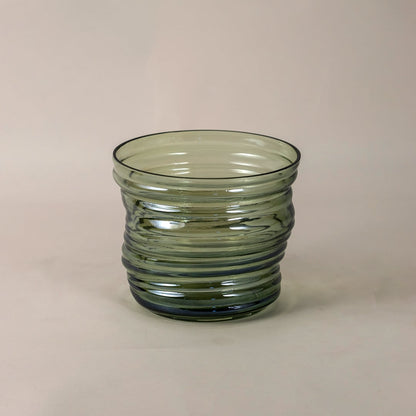 Side view of green ribbed glass vase highlighting its artistic contours and symmetrical ripple design.
