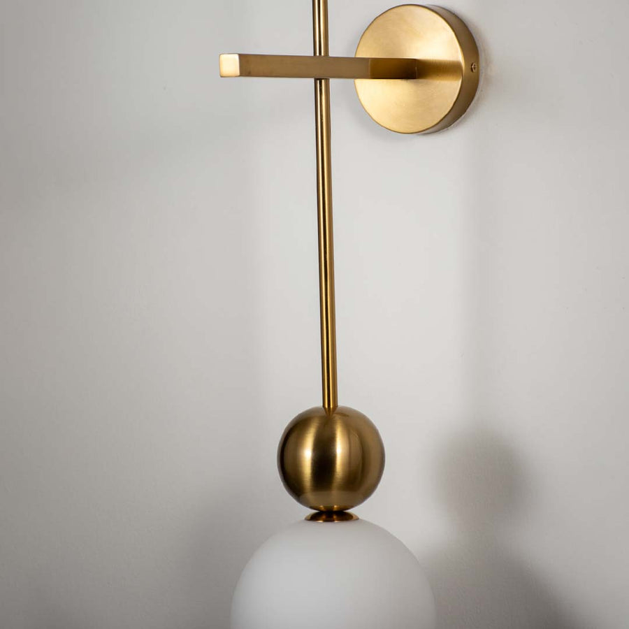 Minimal wall light with gold rod design and round base on neutral background modern decorative lighting perfect for living room decor.