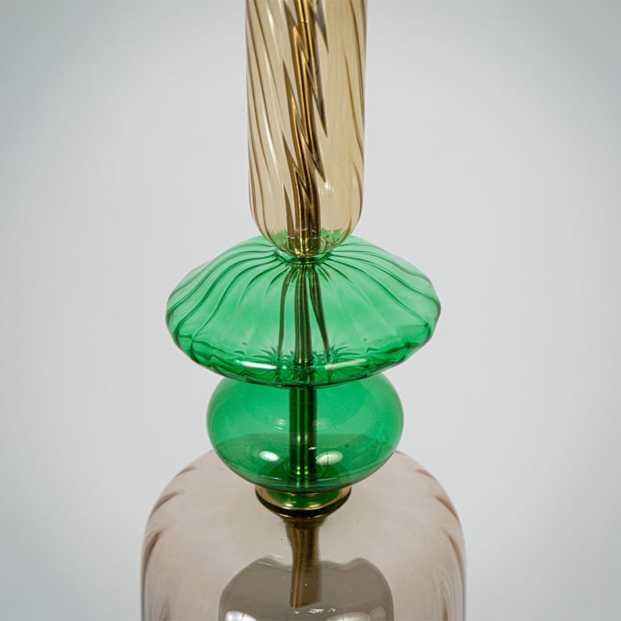 Closeup of clear glass pendant light with green details and twisted stem showcasing artisan craftsmanship.
