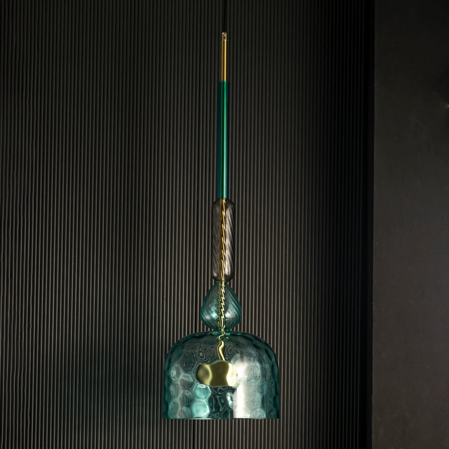 Rosetta teal glass pendant light off against a dark background highlighting its artistic glass texture.