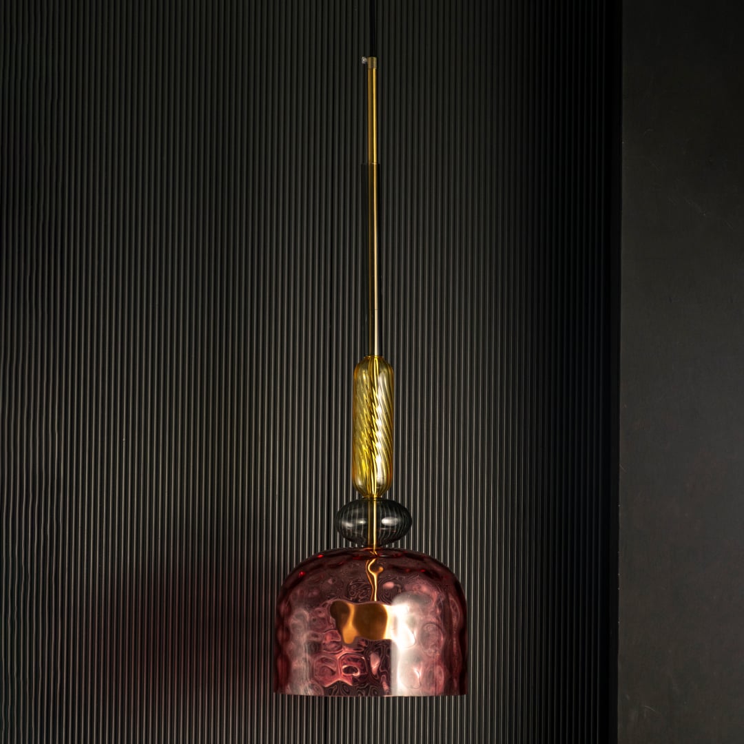 Rosetta pendant light off against a dark background highlighting pink glass and gold details.