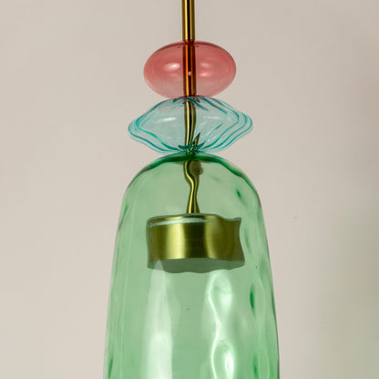 Closeup of mint green glass pendant light with coral accents showcasing artisan details and elegance.