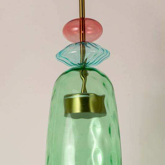 Closeup of mint green glass pendant light with coral accents showcasing artisan details and elegance.