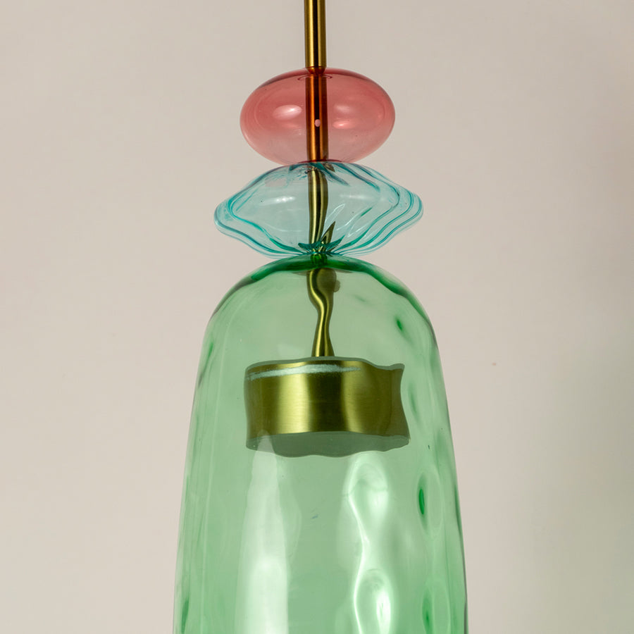 Closeup of mint green glass pendant light with coral accents showcasing artisan details and elegance.