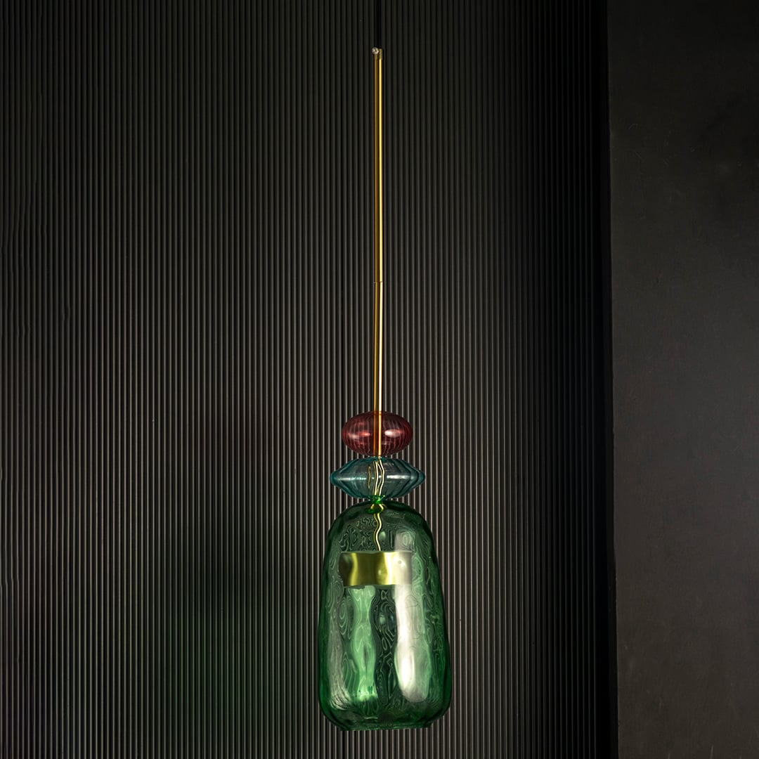 Rosetta green and pink glass pendant light off against a dark background emphasizing its sculptural glass texture.