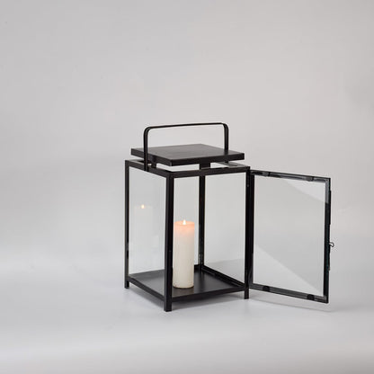 Black metal lantern with open glass door and candle holder for elegant tabletop decor styling.