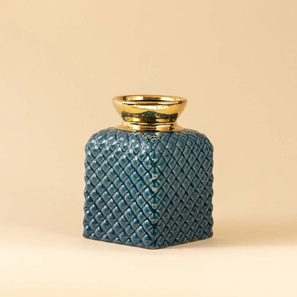 A set of textured ceramic vases in assorted colors and sizes with gold tops arranged together on a neutral background creating a coordinated decorative display.